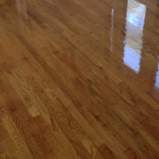 Polished wooden floor with window reflections.