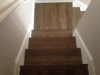 Detail view of stair treads sanded and stained to match new European White Oak wood floors