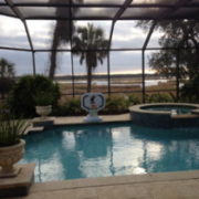 Enclosed pool and spa with scenic view.