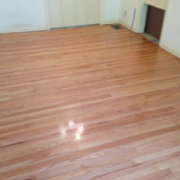 Shiny, polished hardwood floor in empty room.