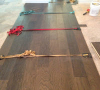 Special straps hold wide wood flooring planks together during installation