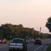 Cars driving on a road near lighthouse.
