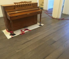 Family piano on carpet on new French Oak wood flooring