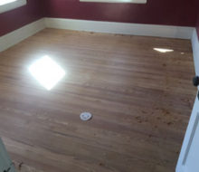 Edge hand scraping old heart pine wood flooring after sanding