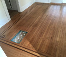 Face nailed white oak flooring with walnut strip border after refinishing