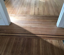 Face nailed white oak flooring with walnut strip border after refinishing