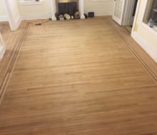 Face nailed white oak flooring with walnut strip border after sanding and hand scraping