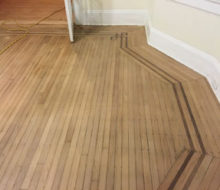 Face nailed white oak flooring with walnut strip border after sanding and hand scraping