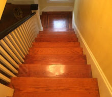 Old heart pine wood stair treads and white oak wood landing with walnut strip border, before refinishing