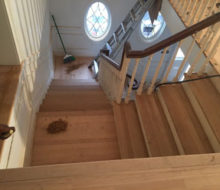 Sanding and hand scraping red oak wood stair treads and landing