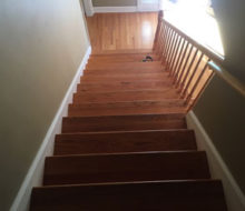 Old, yellowed wooden stair treads and red oak wood flooring prior to refinishing