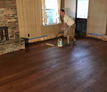 Applying finish to solid red oak plank flooring with walnut pegs