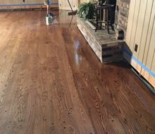 Applying finish to solid red oak plank flooring with walnut pegs