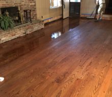 Applying finish to solid red oak plank flooring with walnut pegs