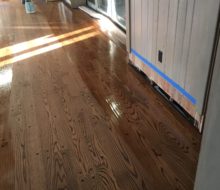 Applying finish to solid red oak plank flooring with walnut pegs