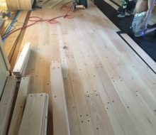 Red oak planks with walnut pegs being installed