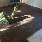 floor sander on old heart pine wood floor, prior to refinishing