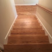 Refinished wooden staircase, rail, and red oak flooring