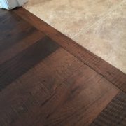 Header board between new engineered Hickory hardwood flooring and tile