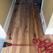 Installing wide Hickory flooring with flooring straps.