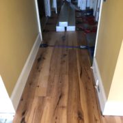 Installing wide Hickory flooring with flooring straps.