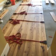 Installing wide Hickory flooring with flooring straps.