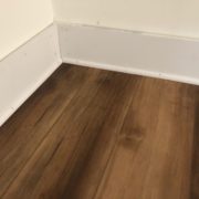 Detail of new baseboards and shoe molding, with Luxury Vinyl Plank flooring