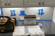 Installing blue glass tile backsplash.