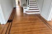 White Oak flooring with Walnut strip trim, after refinishing.