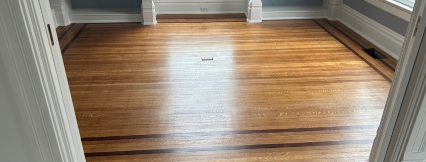 White Oak flooring with Walnut strip trim, after refinishing.